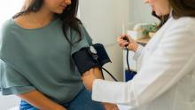 A doctor checks a patient's blood pressure.