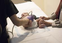 A technician performs an ultrasound on a baby.