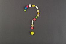 Question mark created from colored pills. 