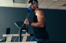 Athlete running on treadmill with elevation mask on 