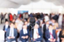 Microphone in front of a conference of people