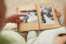 A senior couple looks at an old photo album together