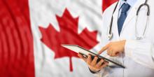 A doctor stands in front of a Canada flag