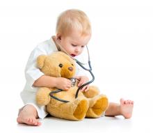 Child using a stethoscope and his senses to look after his teddy bear patient
