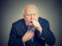Old man coughing into his fist - copd