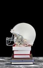 football helmet atop a pile of books