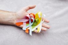 Hand holding all different coloured cancer awareness ribbons 