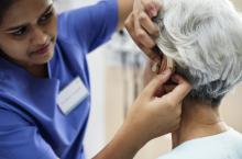 Elderly woman being fitted with a hearing aid