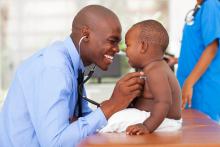 Smiling doctor examining smiling baby boy