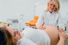 Pregnant woman at a checkup with her female doctor at clinic